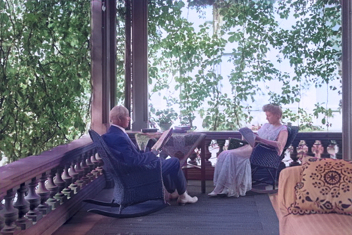 A dated photo of two people reading on their porch