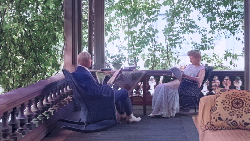 Two people reading on their porch